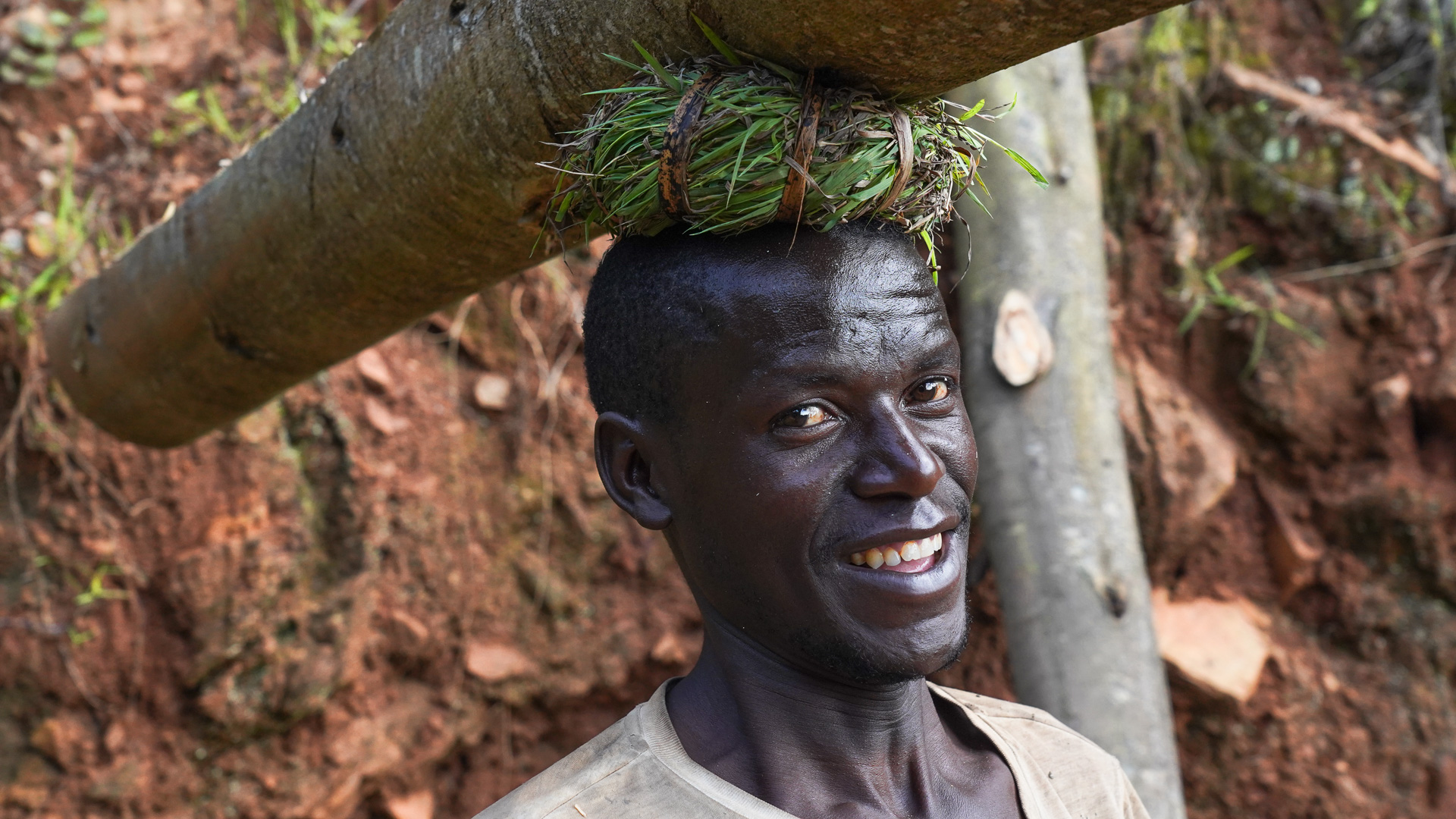 Rwanda, portrait d'un paysan portant un tronc sur la tête