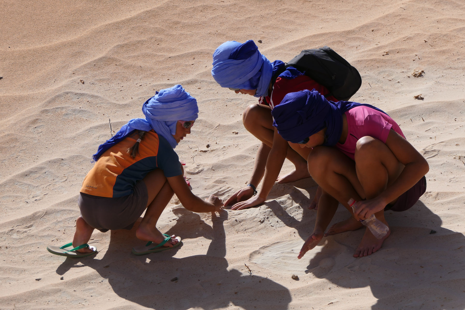 Les 3 enfants jouant dans le sable du désert